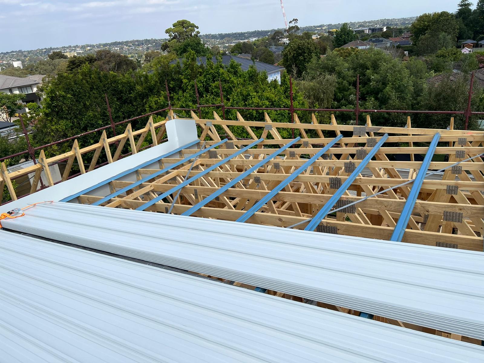 Sheet roofing being laid over new trusses