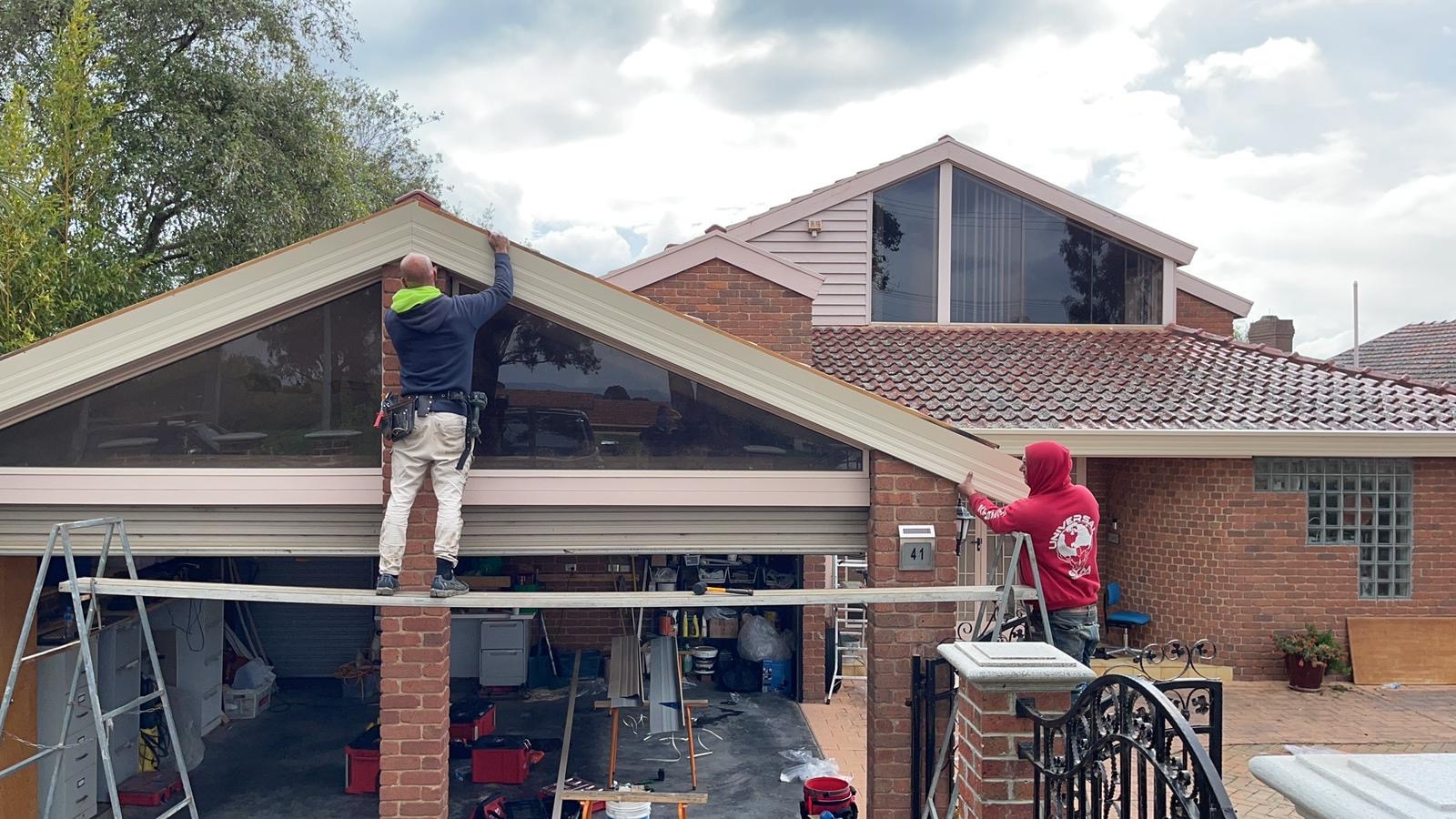 Two roofers installing Colorbond fascia